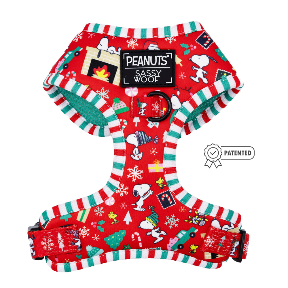 The Sassy Woof Dog Adjustable Harness - Peanuts™ Beagle Bells features festive red with Snoopy and holiday motifs, candy cane striped edges, a center PEANUTS Sassy Woof label, and Patented badge—ideal for any Snoopy dog harness fan!.