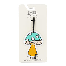 The Sassy Woof Potty Pal - Mushroom is a blue, white-spotted mushroom keychain waste bag holder attached to a branded card—an ideal dog leash accessory. Visit www.sassywoof.com at the bottom of the card.