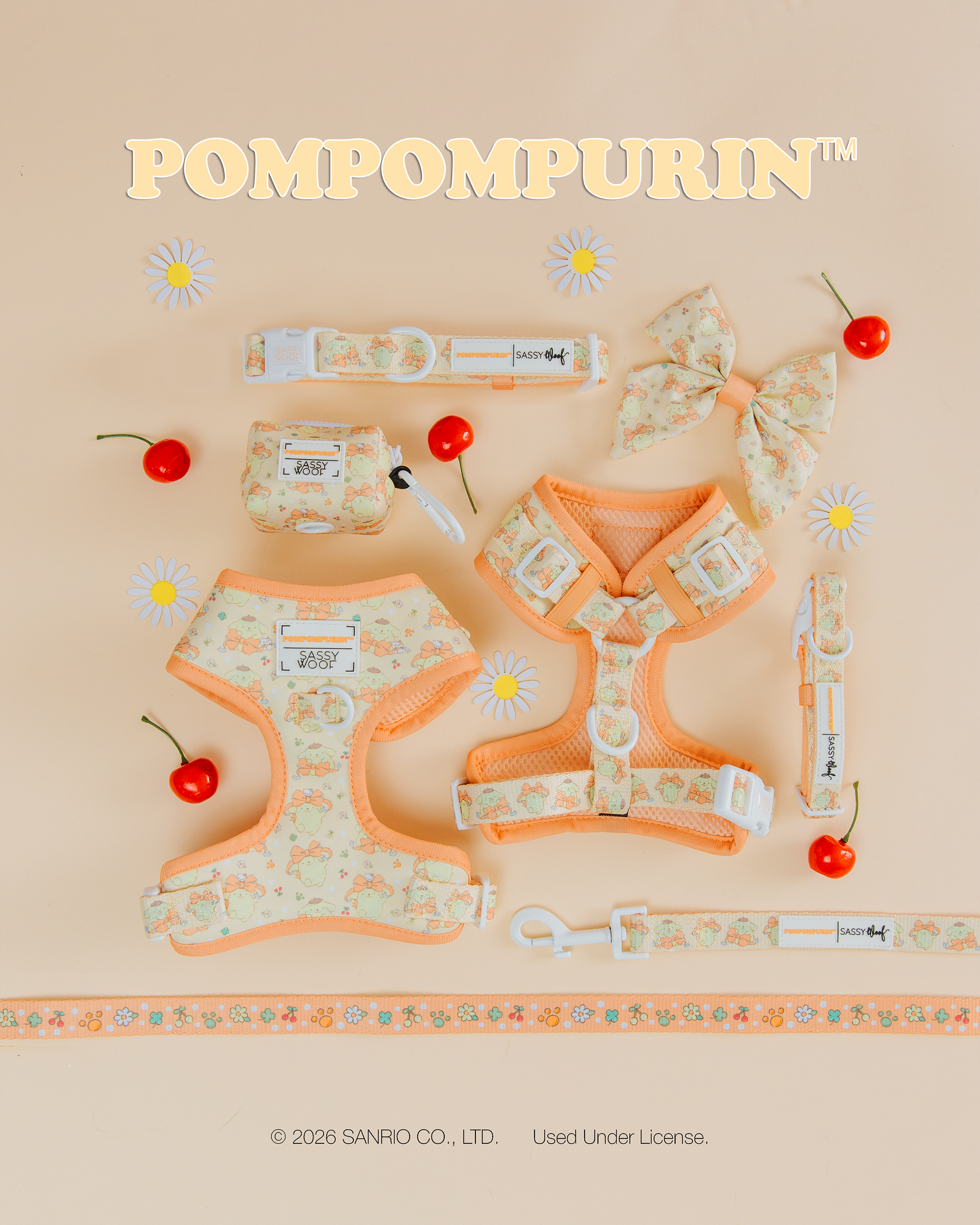 Flat lay of pastel orange and cream Sassy Woof pet accessories, including the Dog Collar - Pompompurin™, harnesses, a bow, leash, bag, and strap with cherry accents on a pale peach background.