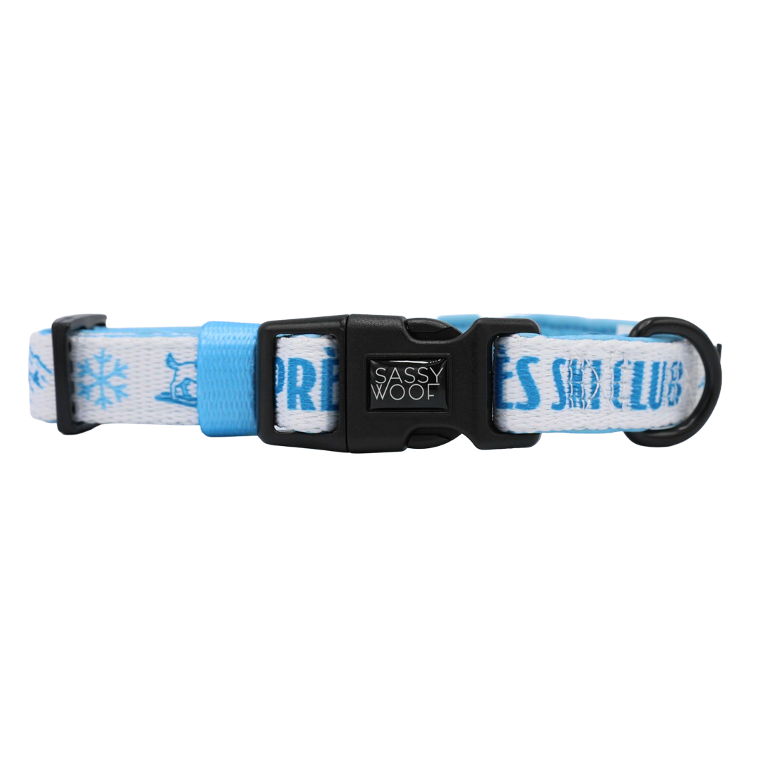 Introducing the Sassy Woof Dog Four Piece Bundle - Après Ski Club: this blue and white adjustable dog collar is adorned with snowflake designs and the words APRÈS SKI CLUB. Perfect as a winter accessory for your pup, it features a durable black plastic buckle branded with Sassy Woof and a sturdy black metal D-ring for easy leash attachment.
