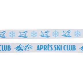 Introducing the Dog Two Piece Bundle - Après Ski Club by Sassy Woof: featuring a white ribbon adorned with blue images of a dog on skis, snowflakes, mountains, and the text “APRÈS SKI CLUB.” This charming bundle is perfect for pairing with your cozy winter dog leash or Après Ski Club dog harness. The playful design makes it a stylish accessory for any pup ready to hit the slopes or enjoy après-ski cuddles.