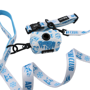 The Sassy Woof Dog Collar Three Piece Bundle - Après Ski Club features a white leash adorned with blue ski-themed designs and “APRES SKI CLUB” text, paired with a matching dog collar and waste bag holder with a black clip, all displayed on a white background—ideal for chic, winter-ready dog accessories.
