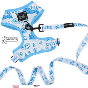 Outfit your pup in style with the Sassy Woof Dog Two Piece Bundle - Après Ski Club, featuring a blue and white adjustable harness and cozy winter-themed leash adorned with illustrations of cabins, ski lifts, snowflakes, and mountains. This set proudly displays Sassy Woof branding and a patented badge for added flair and comfort.