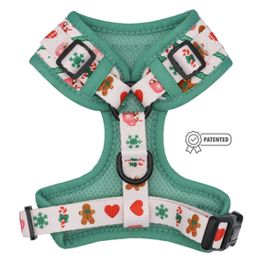 The Sassy Woof Dog Adjustable Harness - Cocoa & Cookies is a green and white custom printed neoprene harness featuring festive patterns like gingerbread men, snowflakes, hearts, and candy canes. This holiday harness includes a patented symbol displayed to the right of the harness.