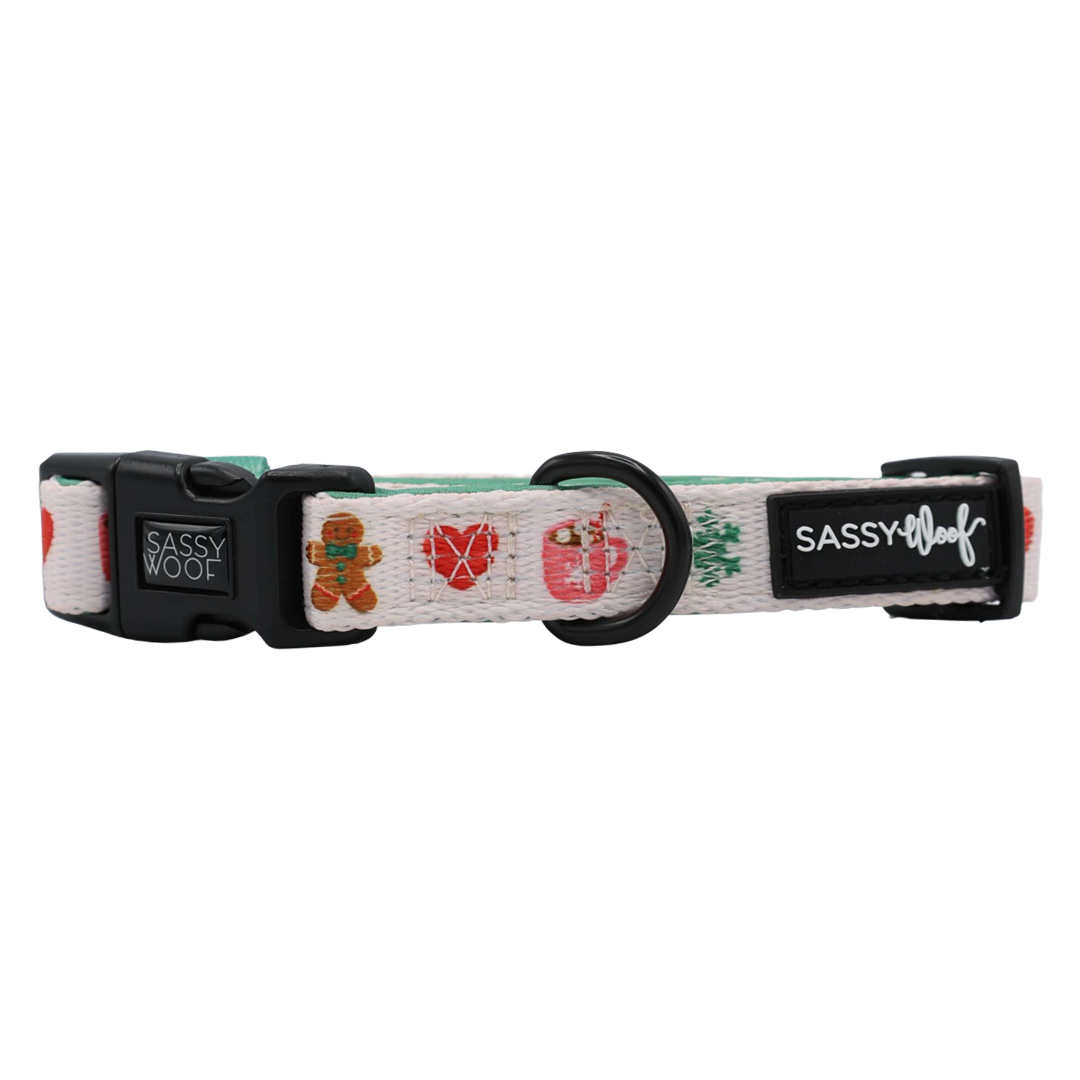 Elevate your pup’s holiday style with the Sassy Woof Dog Collar Three Piece Bundle – Cocoa & Cookies. This festive white collar showcases playful designs like gingerbread men, hearts, and ornaments, and features sturdy black plastic hardware along with signature Sassy Woof branding. Complete the look by pairing it with the matching leash and waste bag holder included in this convenient bundle.