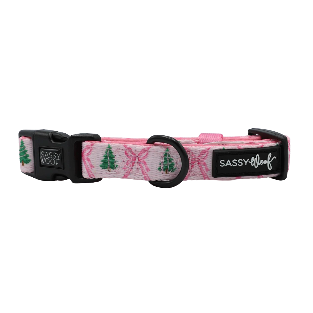 Introducing the Sassy Woof Dog Two Piece Bundle - Pretty in Pine: a festive pink dog collar adorned with green Christmas tree designs, black buckle, sturdy metal D-ring, and signature Sassy Woof patches—perfect for pairing with your favorite winter accessories or adjustable dog harness.