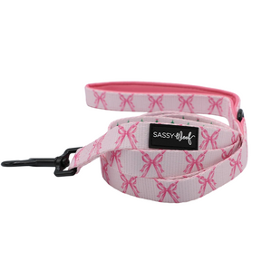 Add a touch of charm to your winter dog accessories with the Sassy Woof Dog Two Piece Bundle - Pretty in Pine. This set features a pink leash adorned with a cute bow pattern, a sturdy black metal clasp, and the signature SASSY Woof label; the inside is solid pink for added style. Perfectly coordinated with an adjustable harness from the Pretty in Pine collection, this bundle makes every walk look adorable.