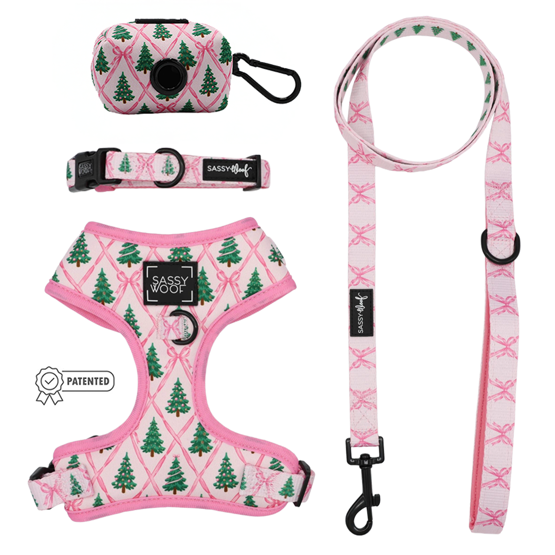 Add a festive flair to your winter dog accessories with the Sassy Woof Dog Four Piece Bundle - Pretty in Pine. This set features a pink harness, leash, adjustable collar, and waste bag holder—all adorned with green Christmas tree designs for a cohesive holiday look. Each piece from the Pretty in Pine collection matches perfectly, while the patented Sassy Woof label appears on the left side of the image, making this bundle an irresistible seasonal accessory for your pup.