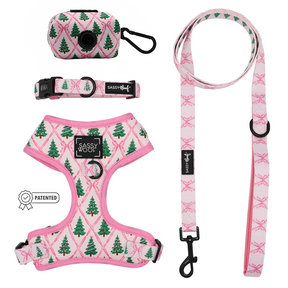 Add a festive flair to your winter dog accessories with the Sassy Woof Dog Four Piece Bundle - Pretty in Pine. This set features a pink harness, leash, adjustable collar, and waste bag holder—all adorned with green Christmas tree designs for a cohesive holiday look. Each piece from the Pretty in Pine collection matches perfectly, while the patented Sassy Woof label appears on the left side of the image, making this bundle an irresistible seasonal accessory for your pup.
