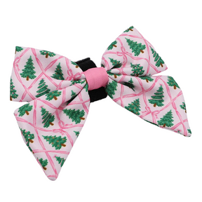 Introducing the Sassy Woof Dog Sailor Bow - Pretty in Pine: this pink ribbon bow showcases a cheerful green Christmas tree pattern, a pink center accent, and a secure black elastic band for easy attachment. As part of our Pretty in Pine collection, it’s the perfect chic winter fashion accessory for your stylish pup!.