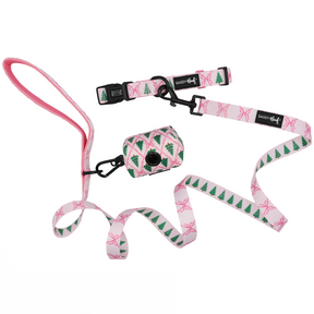 The Sassy Woof Dog Collar Three Piece Bundle - Pretty in Pine features a pink and white dog leash set adorned with green Christmas tree and pink bow patterns, plus a matching collar and waste bag holder—making it the perfect winter accessory set for your pup.