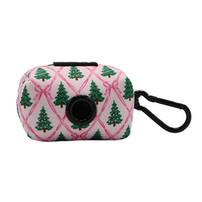 The Sassy Woof Dog Four Piece Bundle - Pretty in Pine includes a pink pouch adorned with green Christmas trees and pink bows, featuring a black circular dispenser and side clip—ideal for matching with your Pretty in Pine dog harness or other winter accessories.