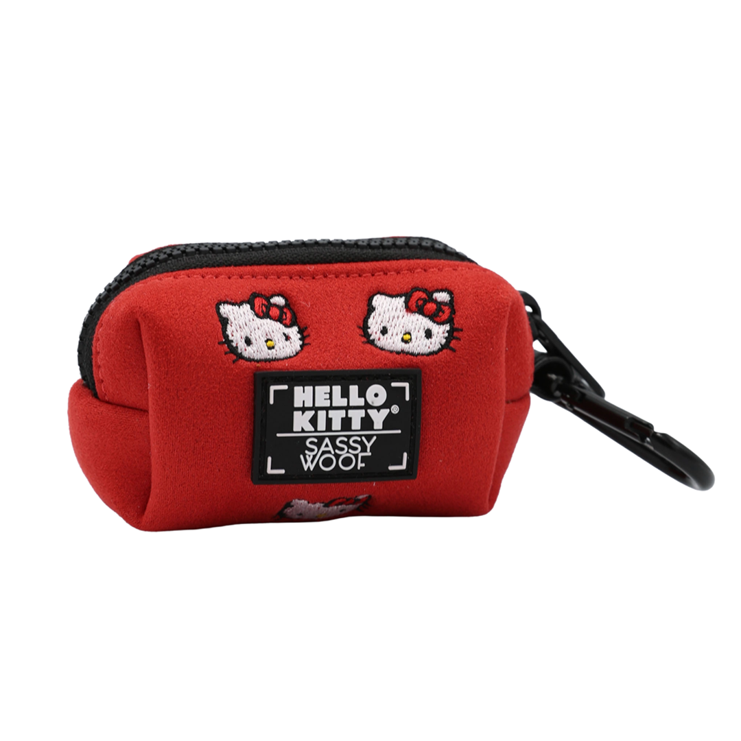 Small red zippered Hello Kitty® Chic dog waste bag holder with two embroideries, a black logo patch, and a black carabiner clip.