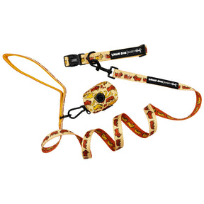 The Sassy Woof Dog Three Piece Bundle - Hot Dawg features a beige leash, collar, and matching waste bag holder with playful cartoon dog graphics—a fun accessory set on a crisp white background.