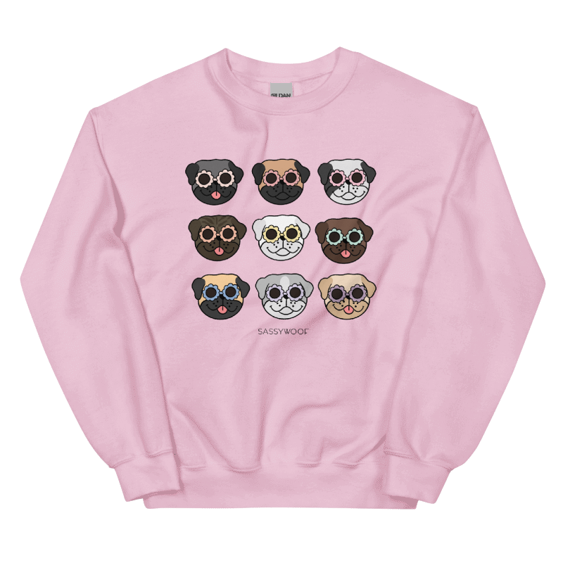 The Sassy Woof Sweatshirt - Pugs is a comfy unisex light pink crewneck featuring nine cartoon pug faces in colorful sunglasses, arranged in a 3x3 grid, with "SASSY WOOF" printed under the design.