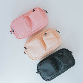 Three Dog Parent Bags by Sassy Woof, each with two front pockets, are arranged diagonally on a white surface. The bag-only pouches come in pink, beige, and black. Ideal for use as a dog treat pouch or for everyday essentials.