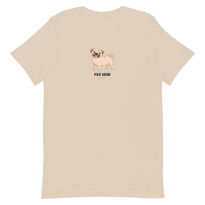 The Sassy Woof Pug Mom Tee is a unisex beige shirt featuring a small tan pug with sunglasses and "Pug Mom" in black on the chest—perfect for any dog lover.