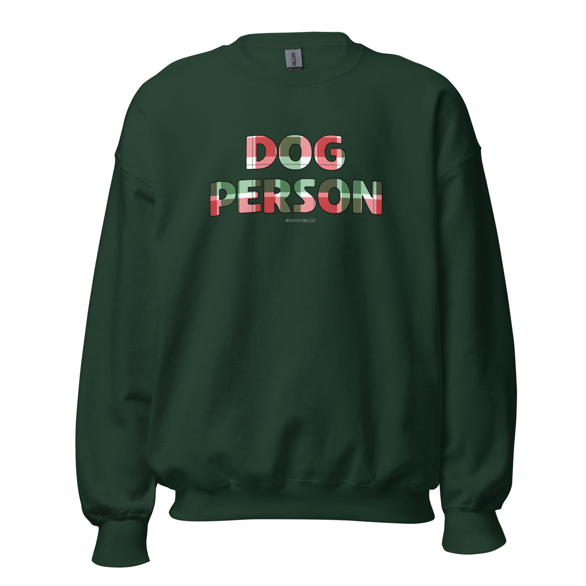 The Sassy Woof "Dog Person Jingle Barks" sweatshirt is dark green, classic fit, with DOG PERSON in bold, multi-colored letters on the front featuring a red, white, and green plaid pattern for a cozy look.