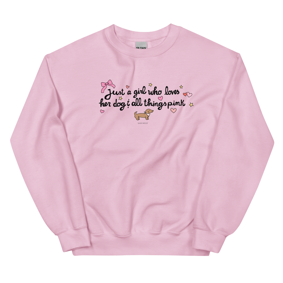 The Sassy Woof Sweatshirt - Just A Girl is a light pink, pre-shrunk top featuring "Just a girl who loves her dog & all things pink" with hearts, stars, a bow, and a cartoon dachshund beneath the text.