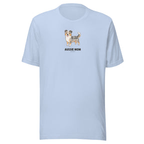 The Aussie Mom Tee by Sassy Woof is a light blue unisex cotton t-shirt with an Australian Shepherd illustration above bold “AUSSIE MOM” text—a perfect gift for proud Aussie dog lovers.