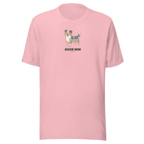 The Sassy Woof Aussie Mom Tee is a light pink unisex cotton shirt with an illustrated Australian Shepherd over "Aussie Mom" in bold black—perfect for proud Aussie owners.