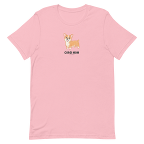 Sassy Woof's Corgi Mom Tee is a light pink shirt featuring a cute cartoon corgi with "CORGI MOM" text centered below the illustration—a perfect choice for fans of this adorable breed.
