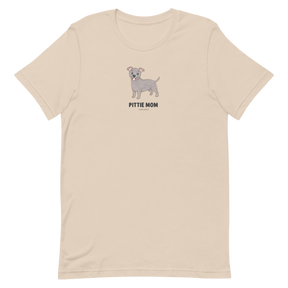 The Pittie Mom Tee by Sassy Woof is a light beige unisex shirt with a cartoon grey pitbull and "PITTIE MOM" text—perfect for pitbull lovers to show off their pup pride.