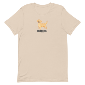 The Golden Mom Tee by Sassy Woof is a beige shirt with a golden retriever illustration and "GOLDEN MOM" text on the front. This unisex tee is perfect for proud pet parents and makes a great gift for golden retriever lovers.