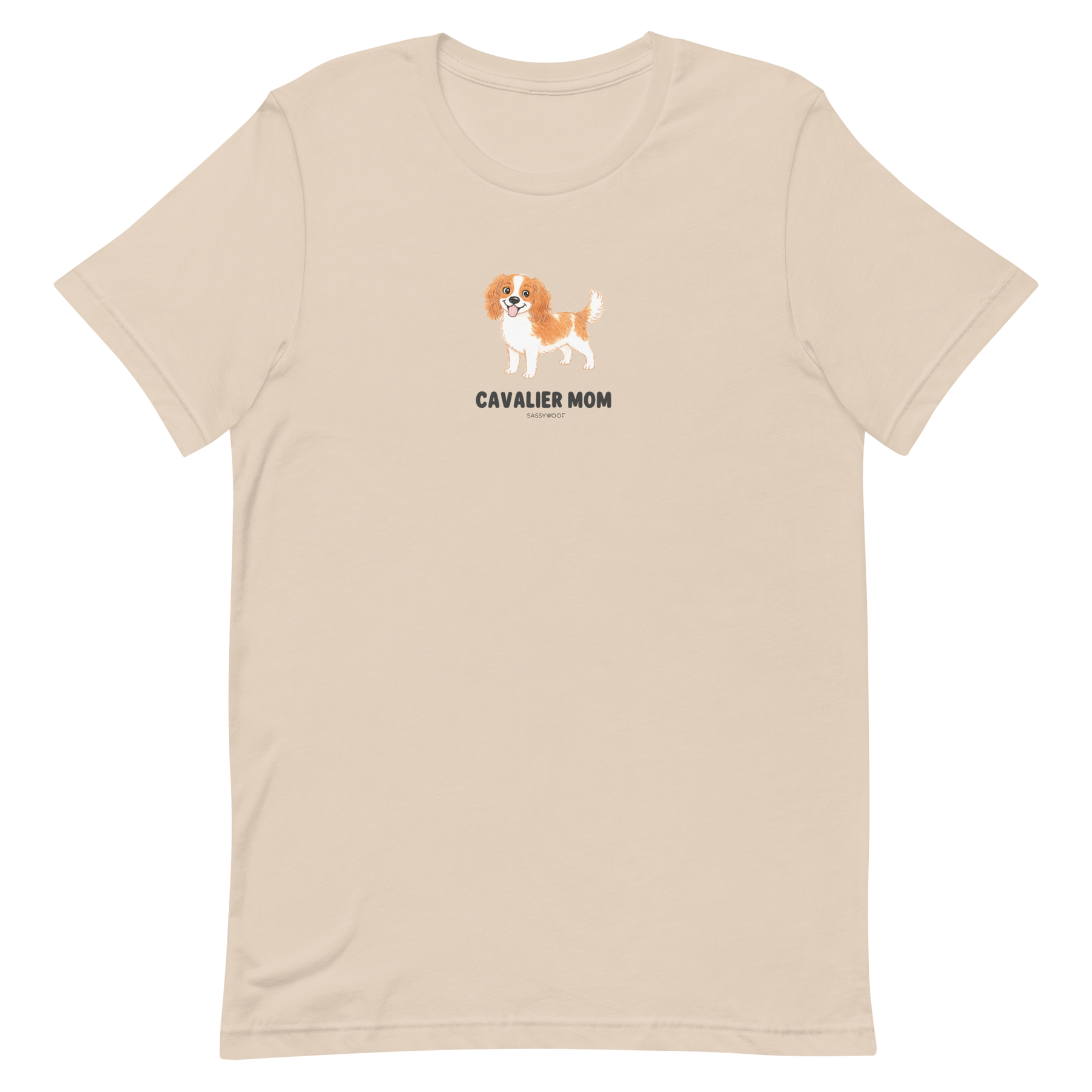 The Sassy Woof Cavalier Mom Tee is a beige unisex shirt with a small brown and white Cavalier King Charles Spaniel illustration and "CAVALIER MOM" in black, centered on the chest—perfect for Cavalier lovers.