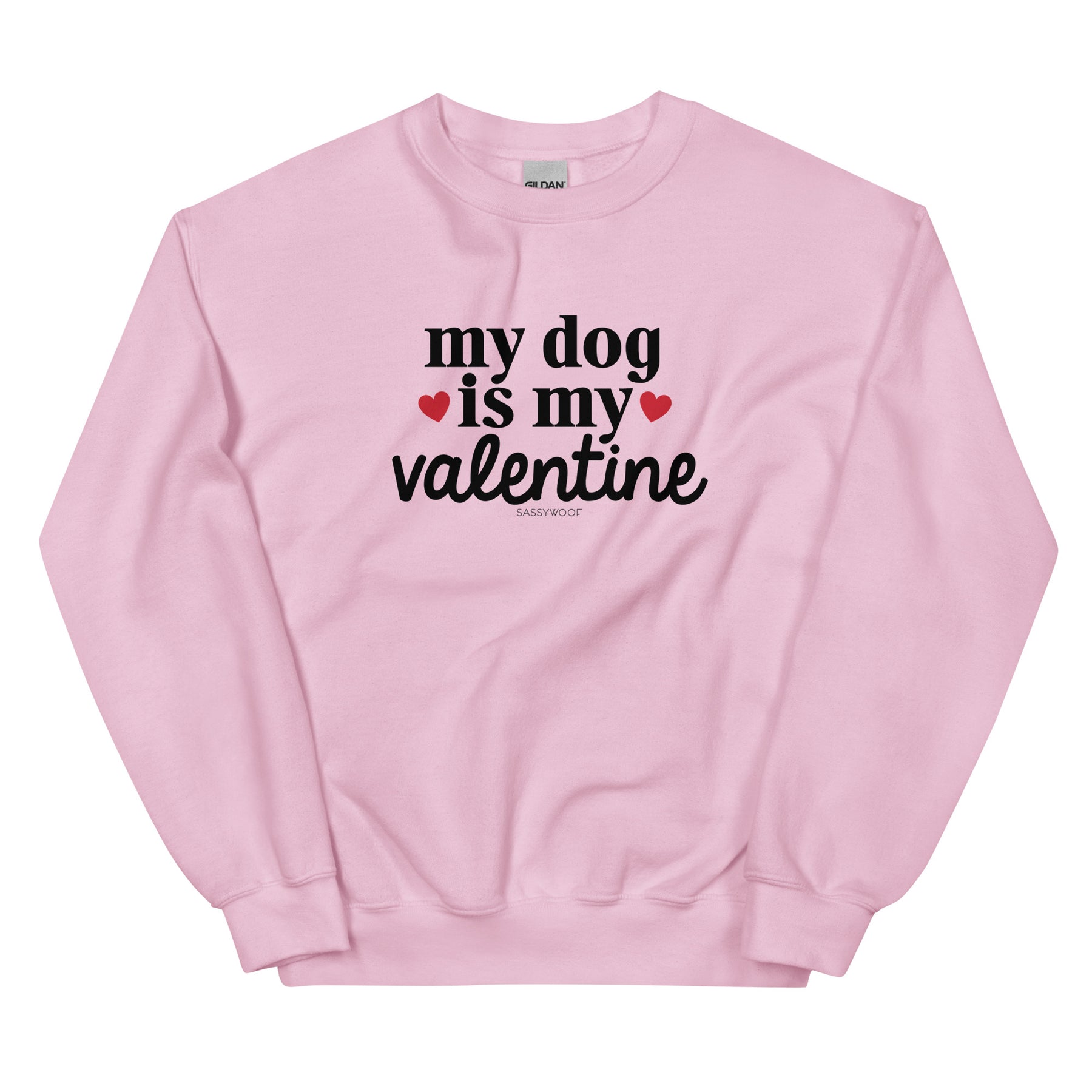 The Sassy Woof "Sweatshirt - My Dog is My Valentine (Light)" features bold black text and pink hearts on a light pink fabric—an adorable choice for any dog lover this Valentine’s Day.